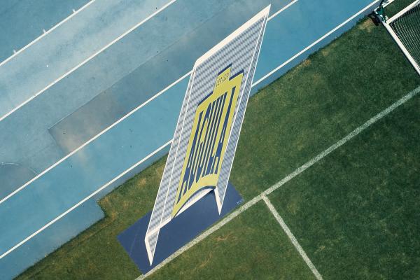 On-field advertisement for Aquila beer. It says "Aquila" in blue font against a yellow background inside of a soccer goal