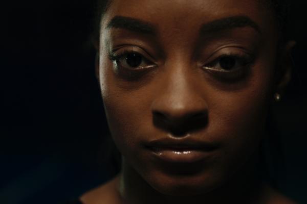 Close up of Simone Biles against a black background