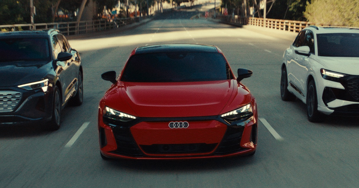 Red Audi car flanked by black car on the left and white car on the right