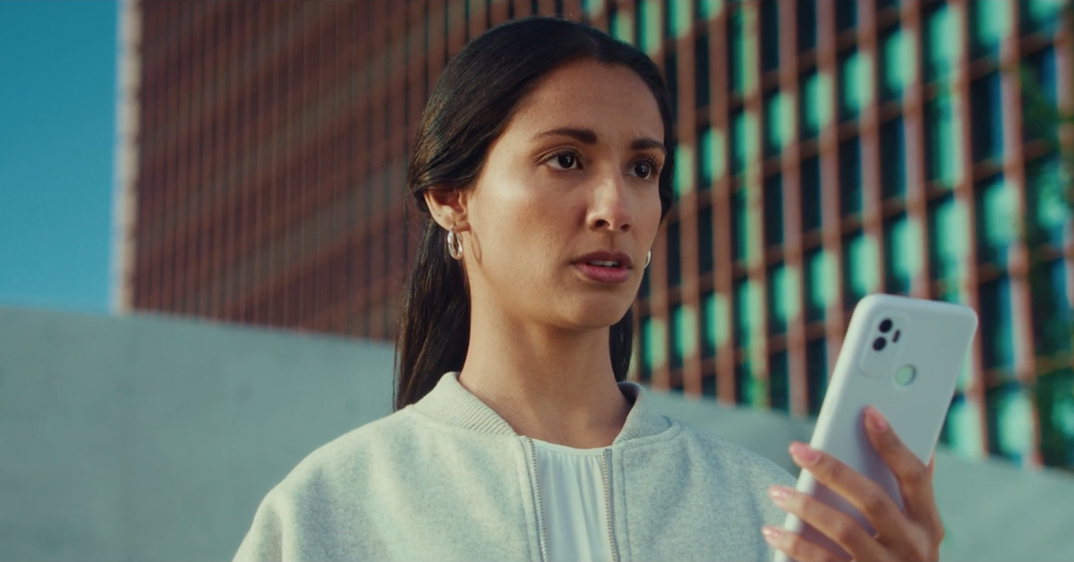 Woman holding phone with skyscrapers in the background