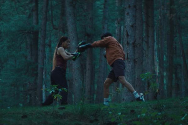 Mother boxer trainig her son in the woods