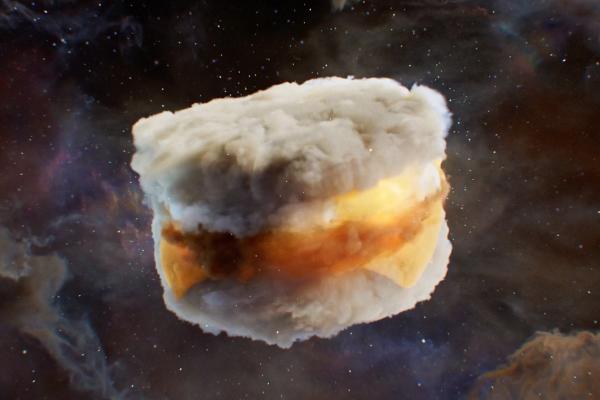 A celestial-themed breakfast sandwich, resembling a biscuit with egg, cheese, and a sausage patty, floats in the center of the frame against a dark, cosmic background filled with sparkling stars and soft nebulae in hues of purple and orange.