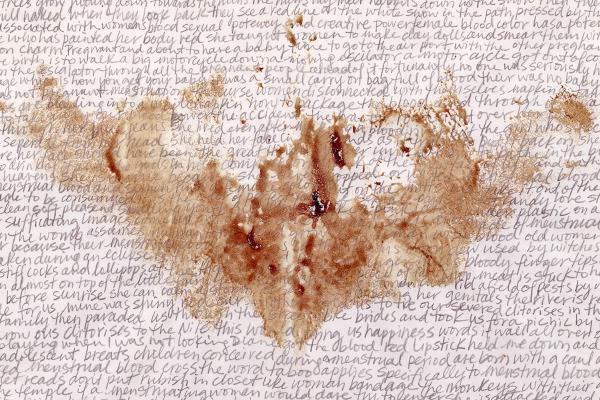 A close-up shows handwritten text on light brown paper, largely obscured in the center by a dark, reddish-brown stain or splatter, resembling dried blood.