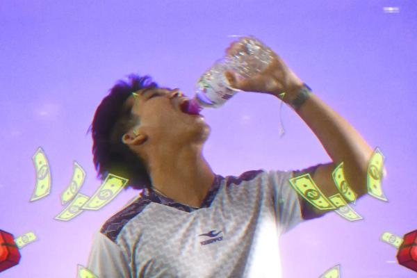 A low-angle shot against a purple background shows a young man in a athletic jersey tilting his head back to drink greedily from a plastic water bottle. Illustrated dollar bills and small gift boxes float playfully around him in a vibrant, arcade-style graphic overlay.