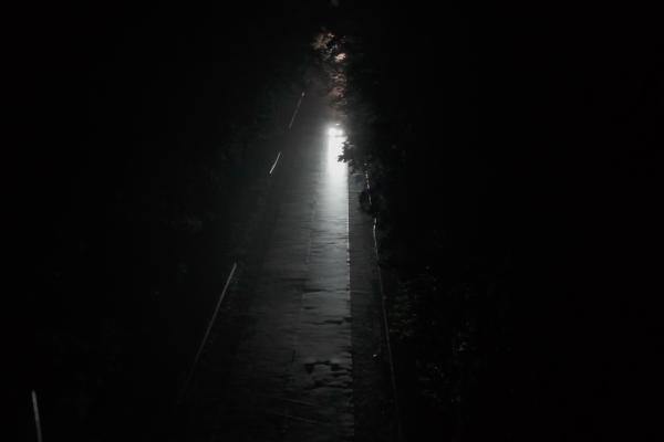 A dark road with a sliver of light down the middle