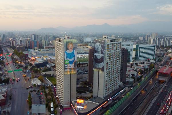 Image from above of two large billboards on the side of skyscrapers in a city. Onone billboard is a Nike ad featuring a well-known athlete. On the other billboard is a MILO ad featuring that same athlete but as a child.