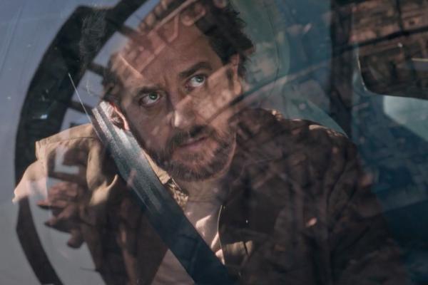 Man in a car looking up through the front windshield