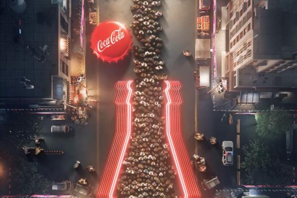 overhead shot of crowd in a queue in the shape of a coca cola bottle. to the left of the queue is a large red coca cola bottle cap