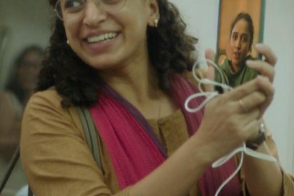 Woman holding phone smiling while on a subway train