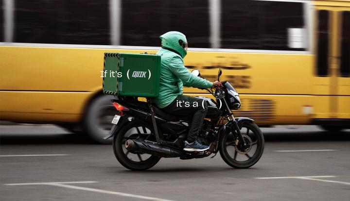 Honda Delivers — Al-Futtaim Trading Enterprises Honda Person making a delviery driving on a motorcylce in front of a yellow bus