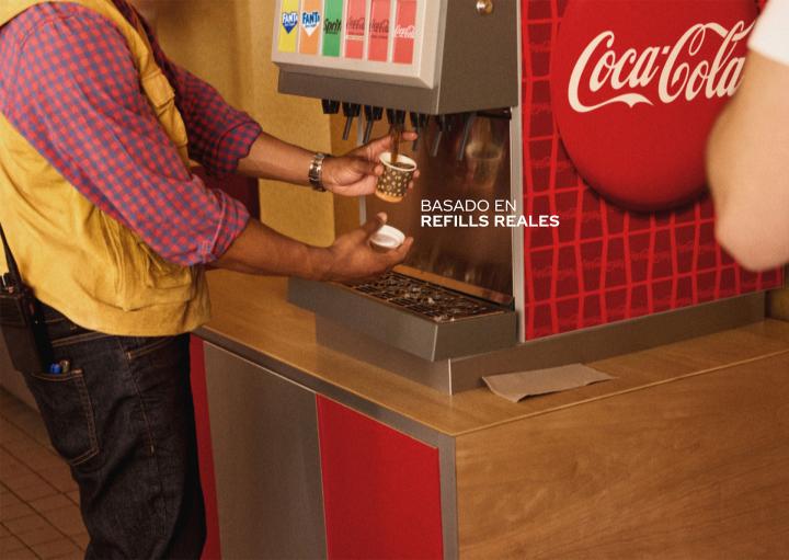 Real Refills — Coca-Cola image of someone filling up a small espresso cup with Coca-Cola from a soda fountain. White copy overlaid: "Basado en refills reales"