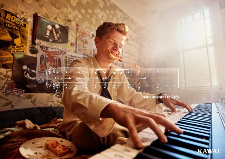Instrumental to Life — Kawai Young man oplaying piano with a piece of toast hanging out of his mouth. There is a white graphic of sheet music superimposed over the image