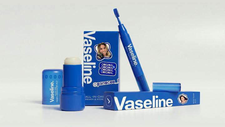 A product shot showing an array of blue Vaseline beauty products on a white background. It includes a Brow Tamer, a Primer & Highlighter Jelly stick, a small square container of the jelly, and two boxes with "Vaseline Original" branding.