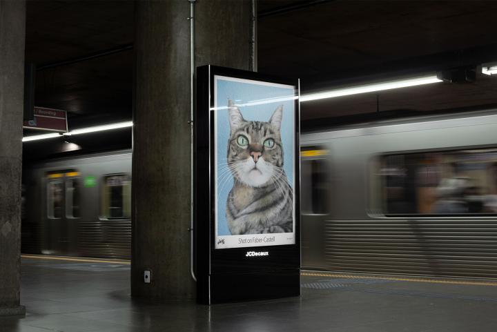 Shot on Faber-Castell — Faber-Castell A mockup of an advertisement in a subway station. In the ad, a close up of a cat with pierchign blue eyes. The copy reads "Shot on Faber-Castell"