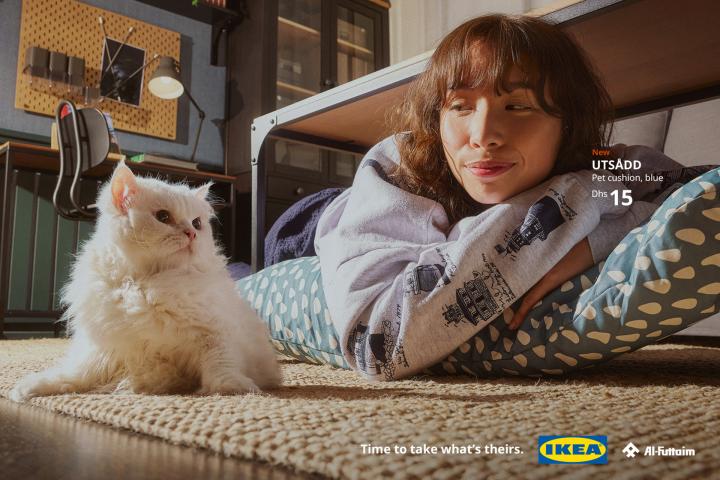 Time to Take What's Theirs — Al-Futtaim IKEA A woman lying on the floor on a pet pillow, her cat looking at her