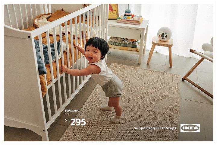 Supporting First Steps — Al-Futtaim IKEA In a baby's bedroom, a baby stands while holding the bars on a crib