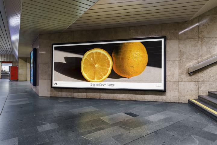 Shot on Faber-Castell — Faber-Castell A mockup of an advertisement in a subway station. In the ad is a picture of an orange sliced in the middle. The copy reads "Shot on Faber-Castell"