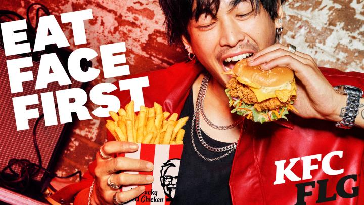 KFC FLG — KFC Young man happy as he brings KFC sandwich to his mouth. Whit copy superimposed over image: Eat Face First