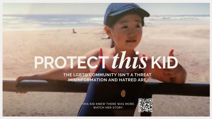 Old photo of a young boy playing on a beach. white text overlaid on the image that says "Protect This Kid" and "The LGBTQ Community isn't a threat. Misinformation and hatred are" 