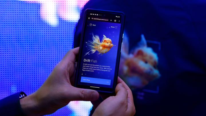 Fishy.AI — IBM x Adobe Hand holding a smartphone screen showing an AI generated image of a messed up fish and the copy "Drift Fish: AI drift can pull the assets you create further and further away from your vision. IBM watsonx helps you create input metrics that grade and flag a model's drift.