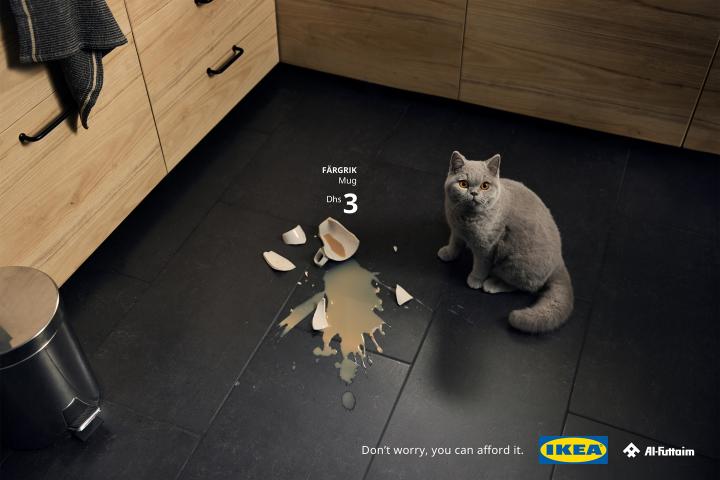 Don't Worry, You Can Afford It — Al-Futtaim IKEA A white cat looking up next to a broken ceramic mug and a spilled beverage
