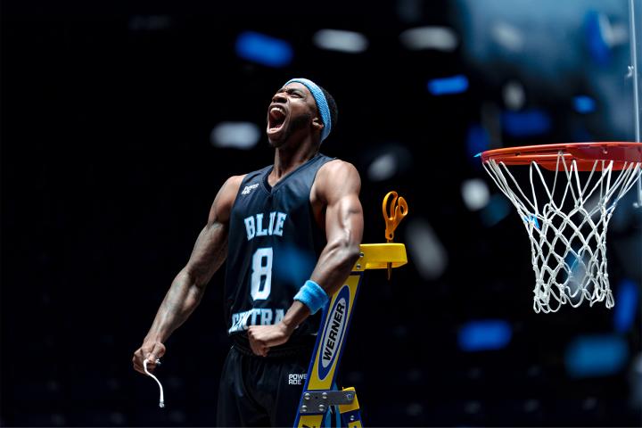 It Takes More to Get This Far Basketball player in navy blue jersey and headband yelling in celebration