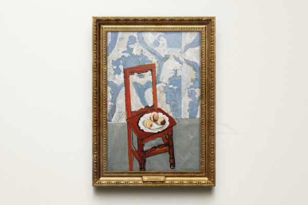 Classic painting framed in gold. The painting depicts a red chair against a blue and white wallpaper, with a plate on the seat.