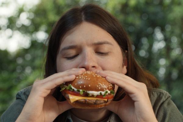 Girl biting into a sandwich with her eyes closed