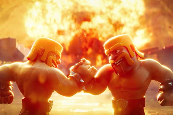 A dynamic image featuring two animated barbarian-like figures, each with a yellow helmet and prominent mustache, engaged in a handclasp or fist-bump. They are smiling broadly at each other. Behind them, a massive, vibrant orange and yellow explosion fills the background, casting a dramatic glow over the entire scene.