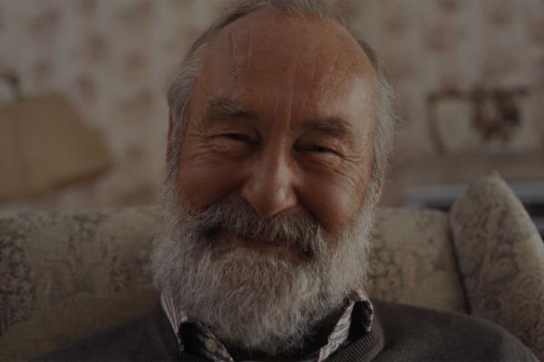 Elderly man with gray beard smiling