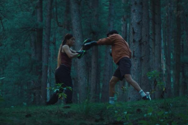 Mother boxer trainig her son in the woods