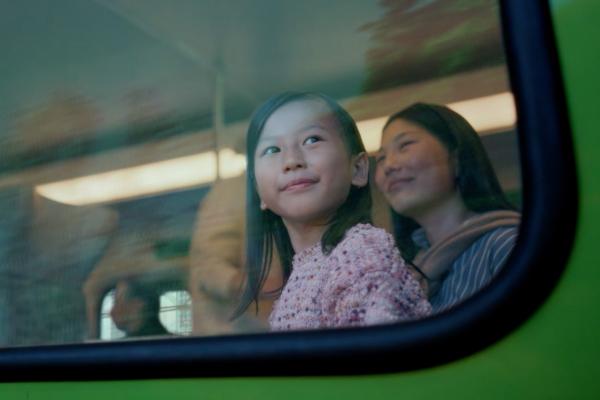 Young child looking out the window of a train