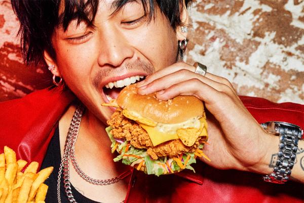 Young man happy as he brings KFC sandwich to his mouth