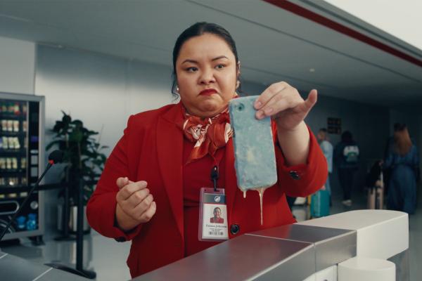 Airline staff at boarding area holding a phone that is dripping with an unknown substance