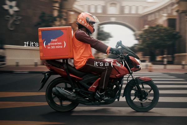 Person on Honda motorbike making a delivery. Copy that says "If its: (your groceries in 30 minutes)" and "It's a" with parenthases marks around the Honda logo on the motorcycle 