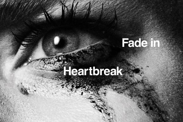 Dramatic high-contrast black-and-white poster of an eye with tear-streaked mascara, overlaid with typography mimicking film directions: 'Fade in', 'Heartbreak'.