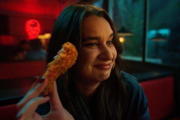 Young person holding KFC chicken and smiling