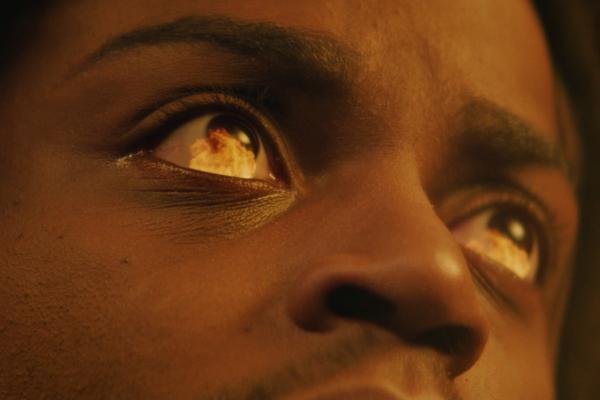 Close up on a face, in the reflection of the eyes we see flames