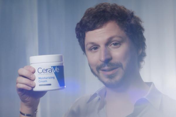 Michael Cera holding CeraVe moisturizer