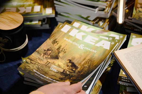 Stack of IKEA catalogs with a hand grabbing the top one