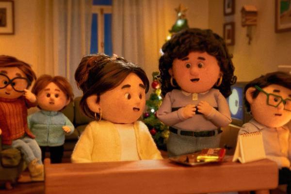 A heartwarming scene featuring three puppets at an airport arrivals hall. A female puppet with brown hair and a striped sweater crouches to pet a small black, white, and tan dog, while a male puppet in a trench coat stands to the right, looking on. A large sign above reads "Llegadas Sala Arrivals Hall 10" with an airplane icon, and a brown suitcase rests on the ground to the left.