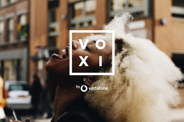 Girl laughing in street wit Voxi logo on top