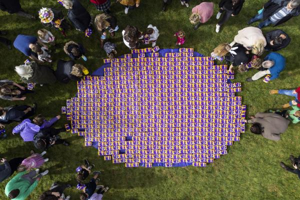 People gather in a field around a display of Cadbury chocolate Easter eggs